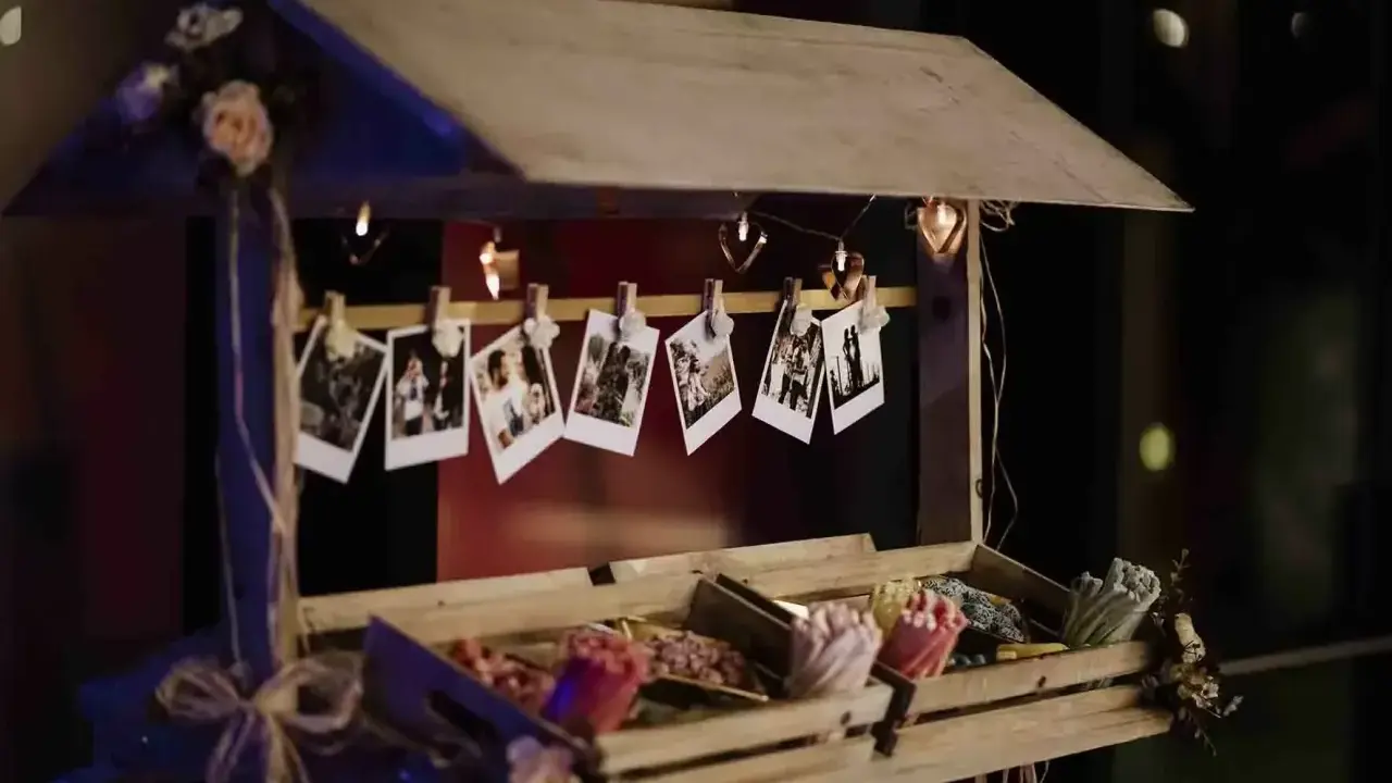 Un carrito de chuches casero decorado con fotos y luces en forma de corazón.