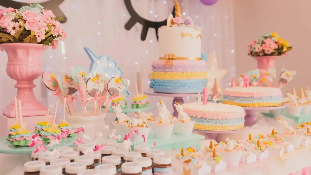 Mesa de dulces temática de unicornios con pasteles, galletas, cupcakes y más postres para una fiesta mágica.