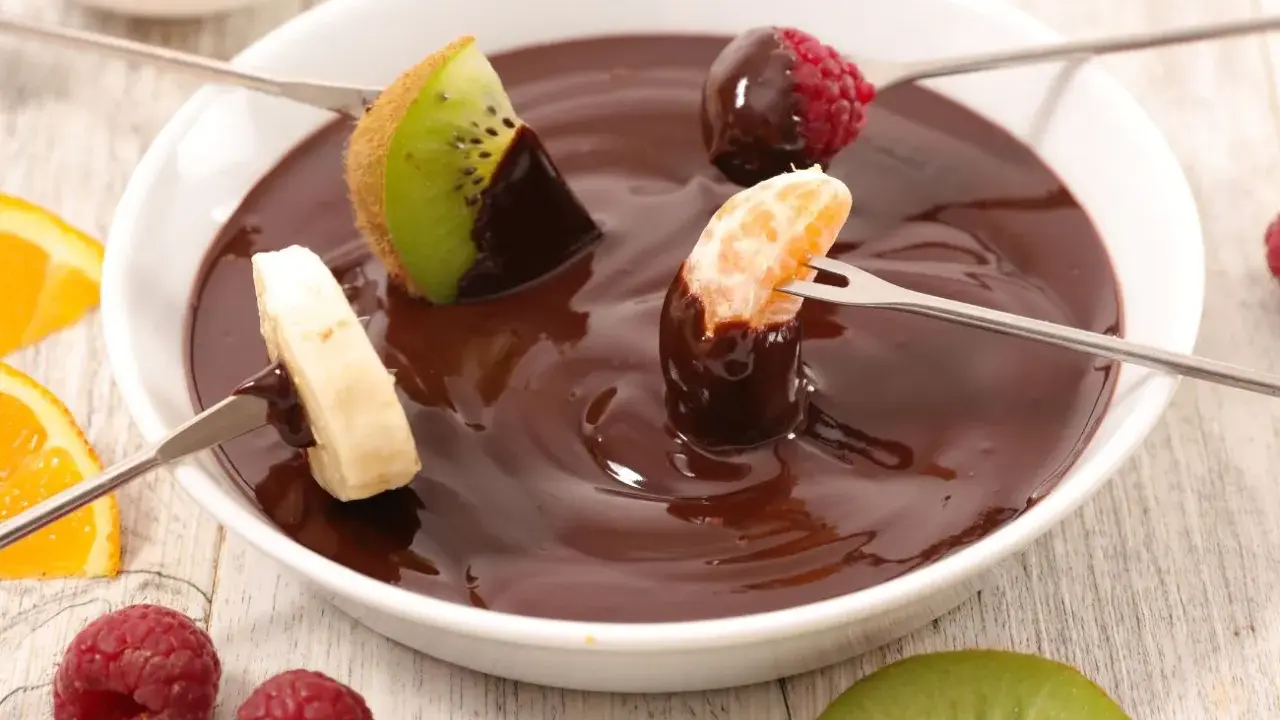 Deliciosa fondue de chocolate receta con frutas: kiwi, plátano, mandarina y frambuesas. ¡Un postre perfecto para compartir!