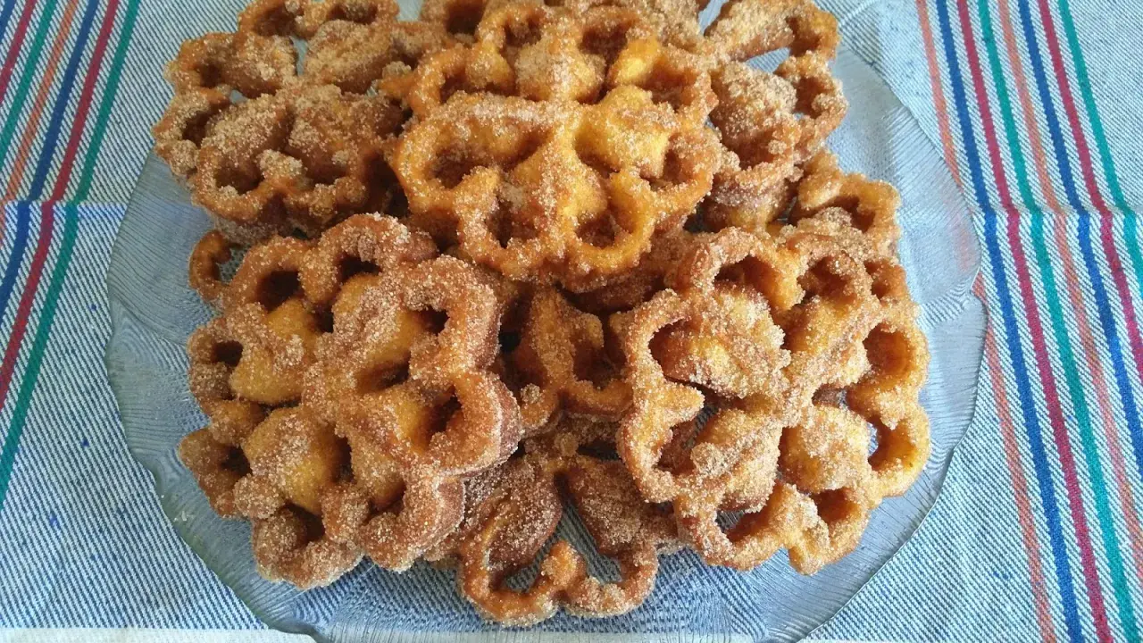 Un plato de flores de Semana Santa, crujientes y espolvoreadas con azúcar y canela, listas para disfrutar.