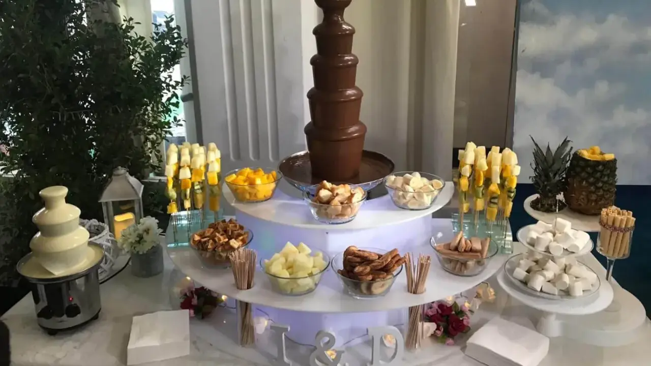 Ideas mesa dulce: fuente de chocolate blanco y negro, frutas, malvaviscos y galletas para una celebración.