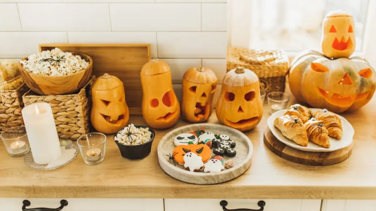 Calabazas talladas, palomitas y galletas decoradas, ¡una mesa llena de dulces típicos de Halloween!