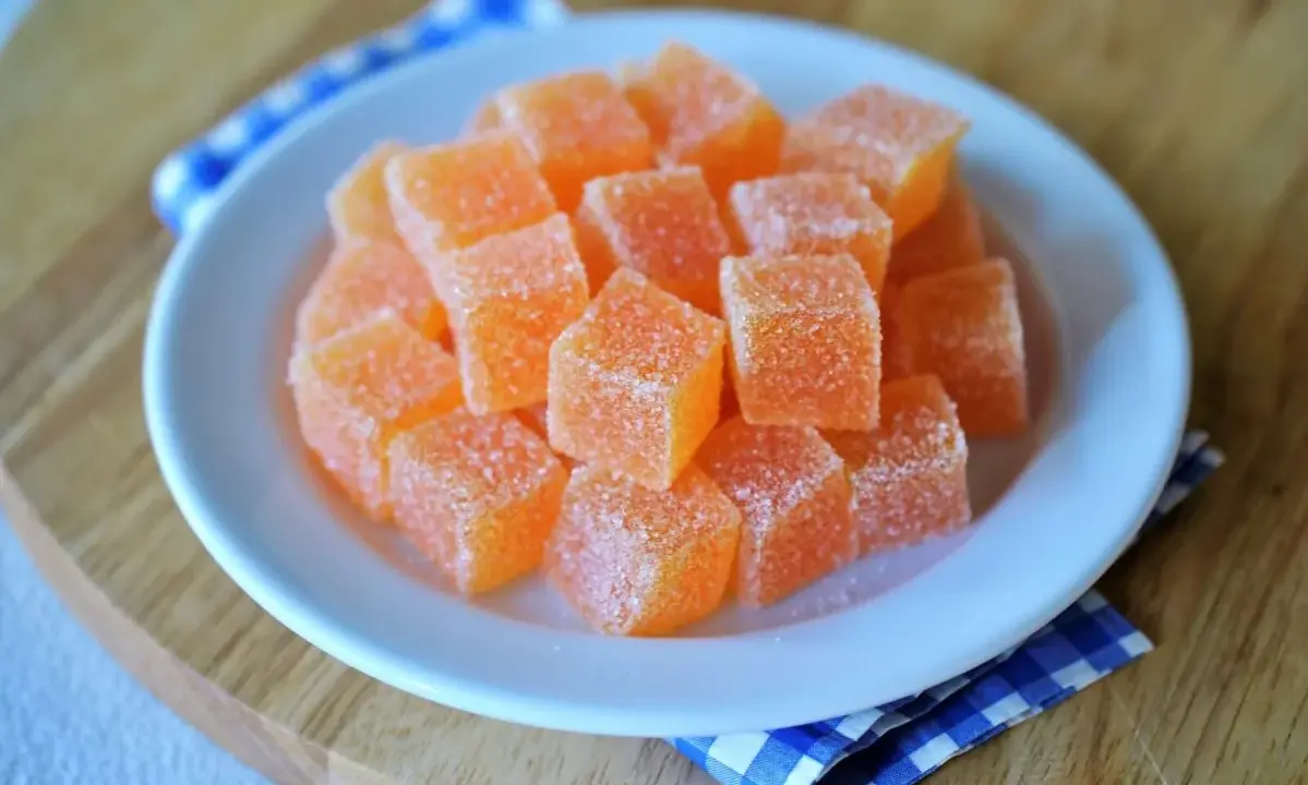Dulces cubos de naranja cubiertos de azúcar, perfectos para aprender como hacer chuches caseras.
