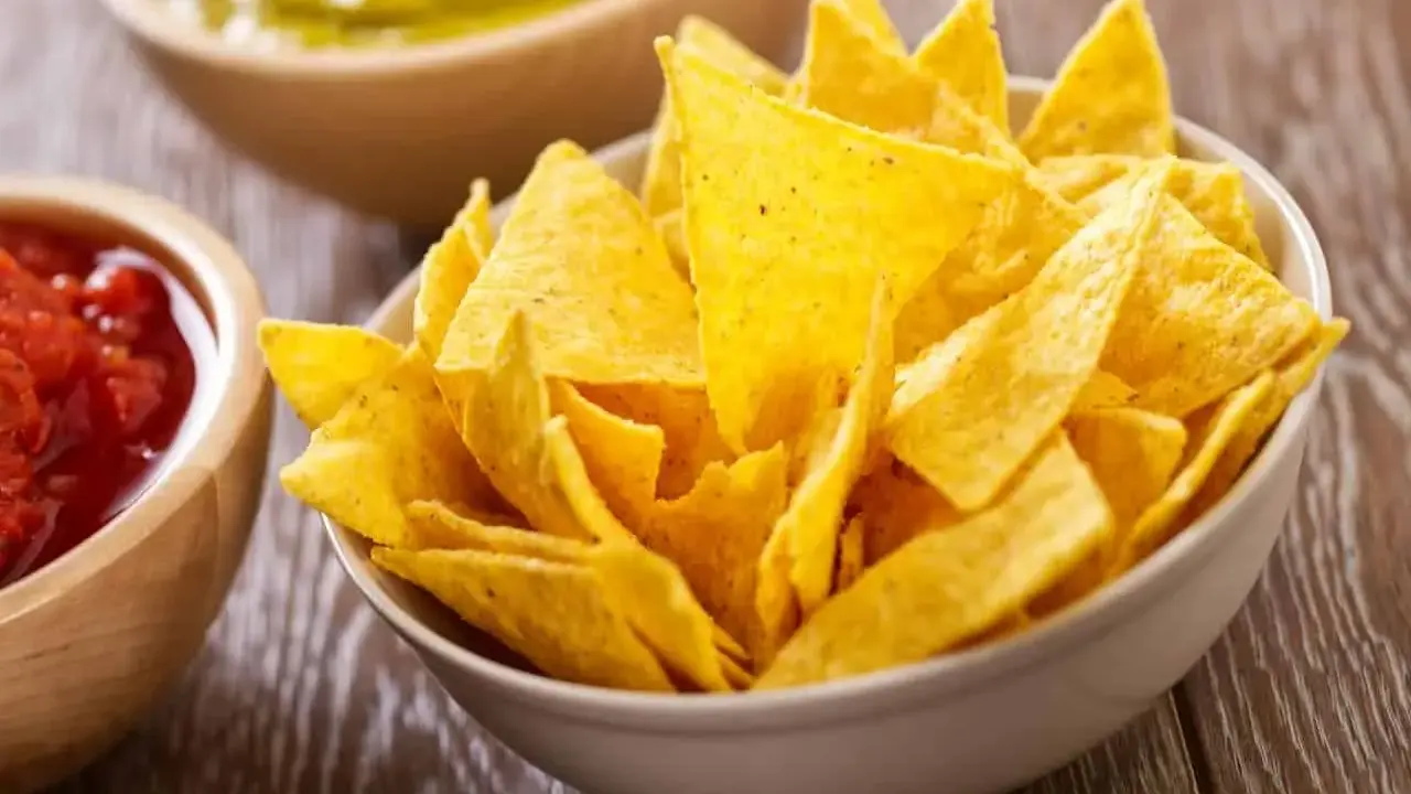 Un tazón lleno de crujientes nachos caseros, listos para ser sumergidos en salsa.