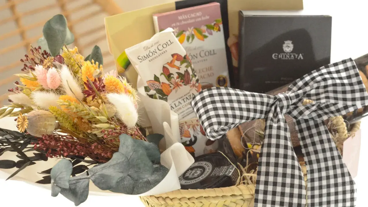 Cesta de regalo con chocolates, flores secas y un lazo de cuadros. Ideal para aprender como hacer una cesta de chuches para regalar.