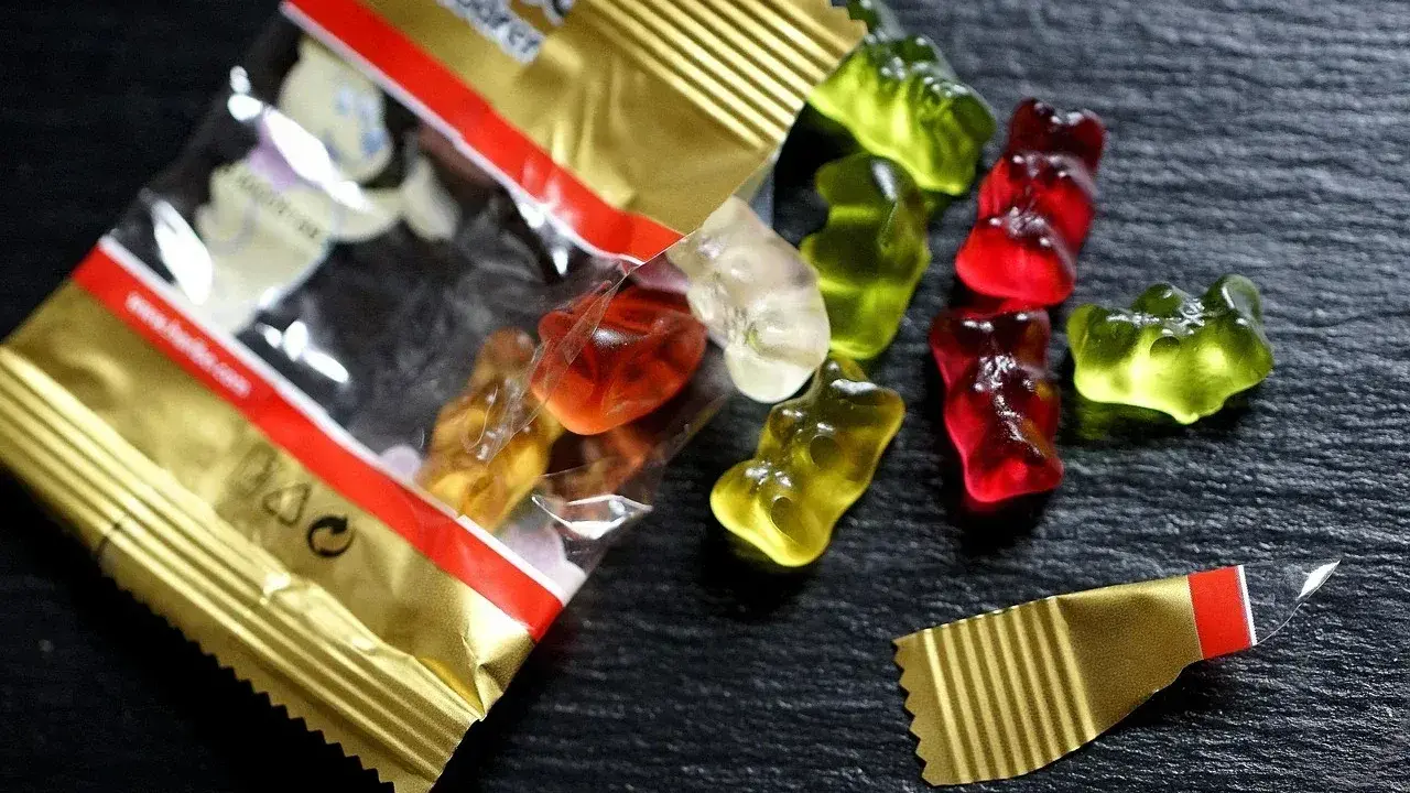 Osos de goma Haribo de colores esparcidos sobre una superficie oscura. ¡Cuidado, las chuches caducan!