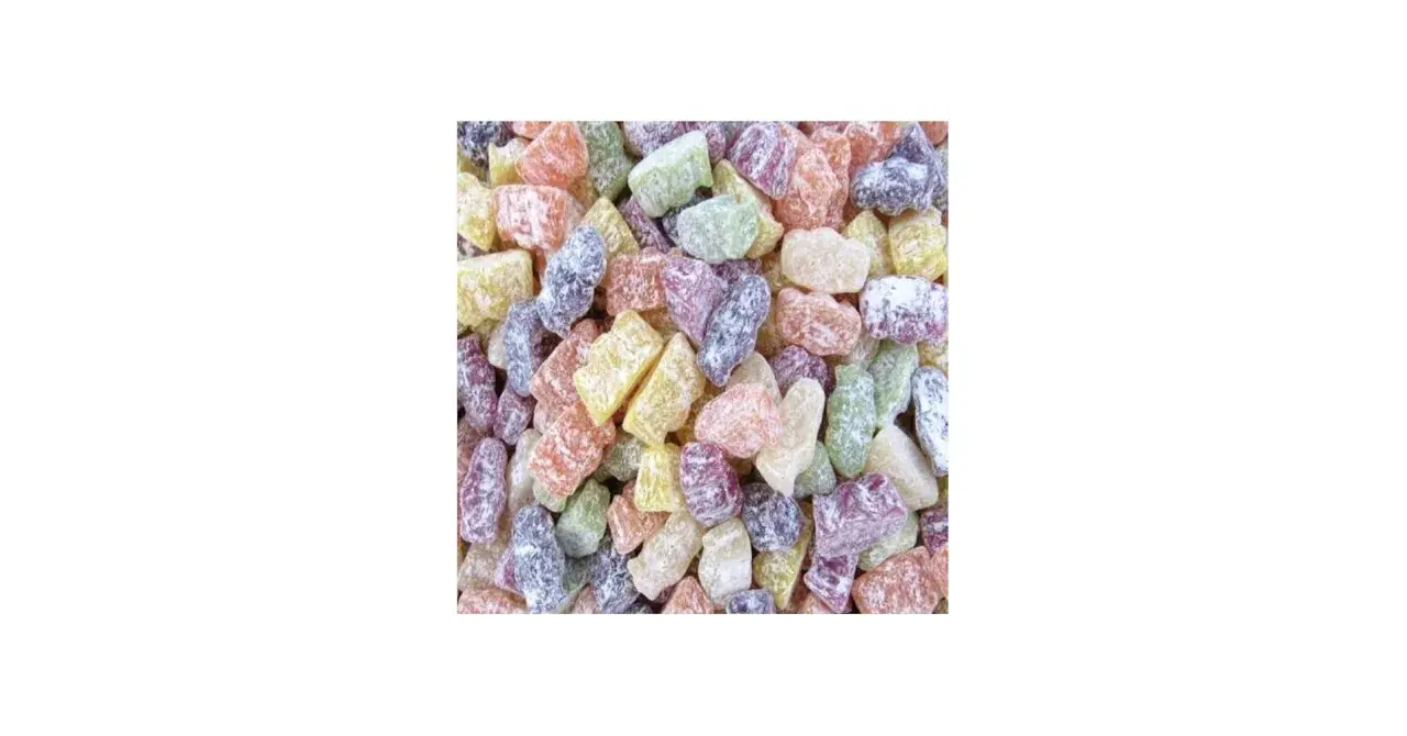 Montón de caramelos de goma de colores, como jelly babies, esparcidos.