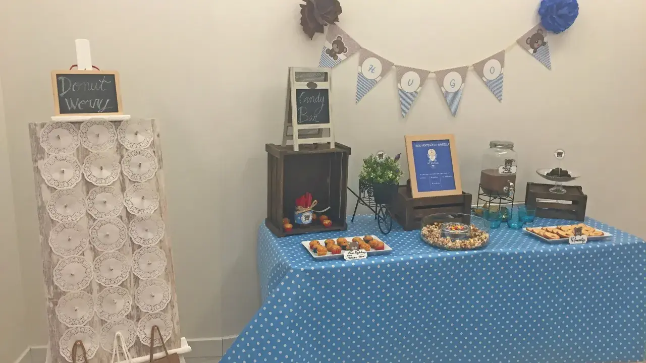 Mesa de dulces con temática de ositos, llena de mini magdalenas, galletas y otros bocadillos. ¡Una fiesta con botes de chuches caseros!