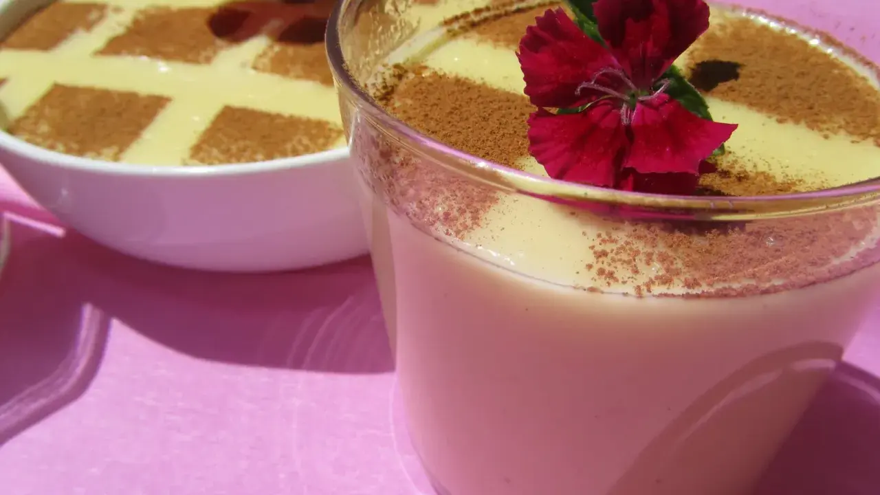 Deliciosas natillas Thermomix, espolvoreadas con canela y decoradas con flores rojas. ¡Un postre casero perfecto!