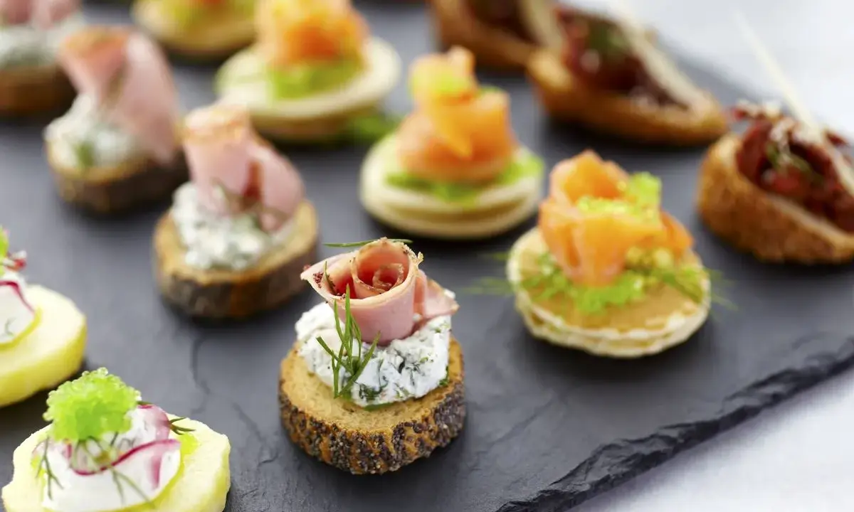Deliciosos entrantes navideños: canapés variados con salmón, jamón, queso y patata. ¡Perfectos para celebrar!