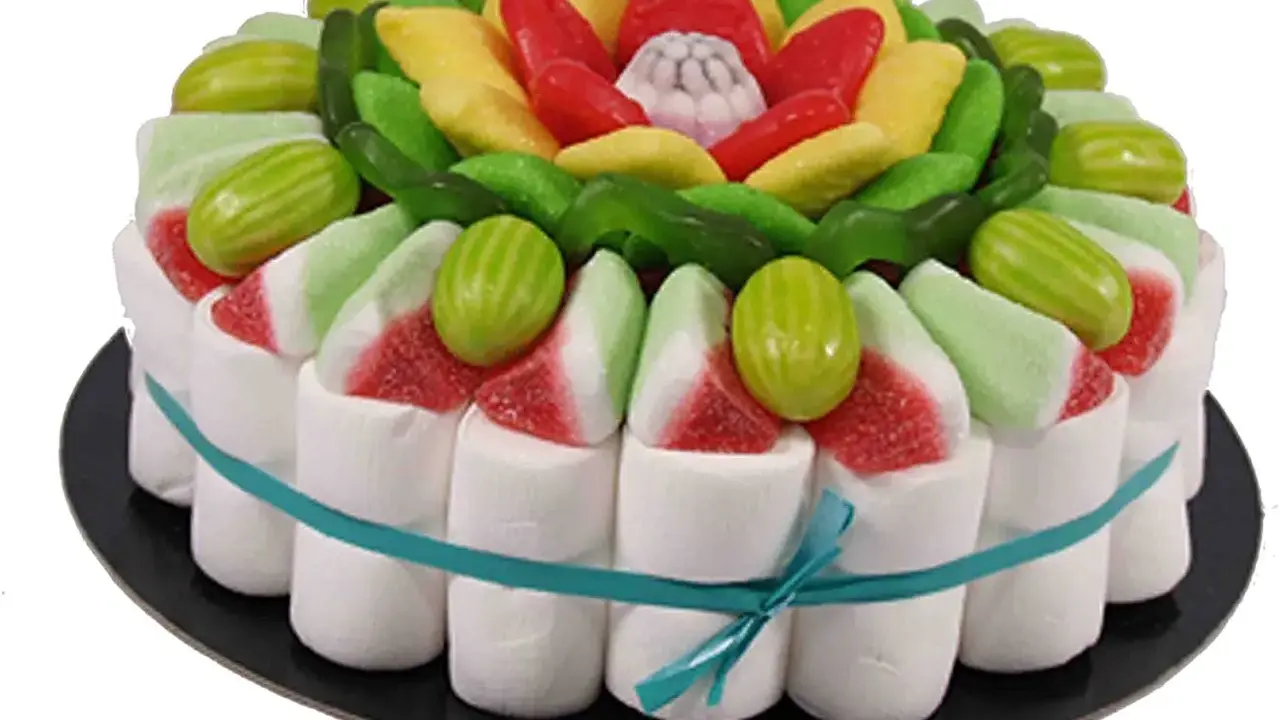 Tarta de chuches sin corcho, decorada con malvaviscos, gominolas rojas, amarillas y verdes, y caramelos con forma de sandía.