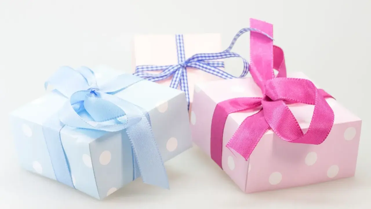 Cajas de regalo con lunares, envueltas en cintas rosas y azules. ¡Perfectas para ideas originales con chuches!
