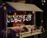 Un carrito de chuches casero decorado con fotos y luces en forma de corazón.