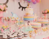 Mesa de dulces temática de unicornios con pasteles, galletas, cupcakes y más postres para una fiesta mágica.