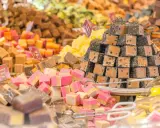 Montón de caramelos de antes, de diferentes sabores y colores, apilados en un puesto.
