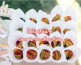 Conos blancos llenos de diferentes tipos de chuches, como gominolas arcoíris y bolitas de colores.