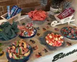 Una mesa llena de todas las chuches del mundo: gominolas azules, rojas, rosas y de muchos colores, dispuestas en cuencos y carretillas.