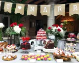 Una mesa de dulces sencillas para una celebración, con pasteles, macarons y cake pops.