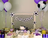 Mesa de chuches del Real Madrid: balones de fútbol, globos, tarta y dulces para una fiesta temática.