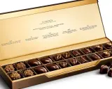Caja abierta de chocolates finos, "la chuche más cara del mundo", con descripciones de sabores inspirados en elementos naturales.