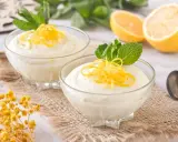Dos copas de cremoso mousse de limón con leche condensada, decoradas con ralladura de limón y menta.