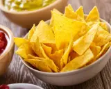 Un tazón lleno de crujientes nachos caseros, listos para ser sumergidos en salsa.