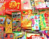 Un surtido vibrante de chuches famosas japonesas, incluyendo Pocky, Caramel Corn y dulces de Hello Kitty y Doraemon.