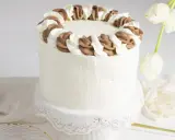 Tarta blanca con borde de nata y chocolate, lista para celebrar.