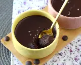 Delicioso mousse de chocolate en un cuenco amarillo, con una cuchara dorada lista para probarlo. ¡Un placer para los sentidos!