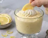 Delicioso mousse de limón receta original, decorado con crema batida y una rodaja de limón.