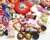 Un surtido de chuches años 60, con caramelos, chicles y chocolates, evocando la nostalgia de la infancia.
