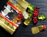 Osos de goma Haribo de colores esparcidos sobre una superficie oscura. ¡Cuidado, las chuches caducan!