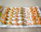Bandeja con variedad de bocaditos salados, perfectos para un picoteo fácil y económico. Hay mini tacos, bolitas cubiertas de frutos secos, brochetas de jamón y canapés con gambas y salmón.