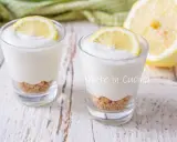 Dos vasitos de mousse de limón con base de galleta y rodaja de limón encima.