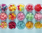 Variedad de tipos de gominolas en cuencos: cubos, frutas, ositos y más, en colores vibrantes.