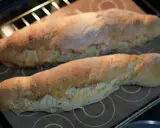 Dos panes dorados recién horneados, hechos con la ayuda de la Thermomix, reposan sobre una bandeja en el horno.