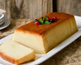 Un delicioso pudin de pan, con una capa dorada y decorado con frutos rojos y menta.