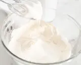 Batidora eléctrica batiendo para crear una deliciosa nata montada en un bol de cristal.