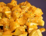 Patatas bravas receta: patatas fritas crujientes cubiertas con una salsa brava cremosa y hierbas picadas.