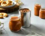 Dulce de leche receta: tarros y lata de dulce de leche, junto a galletas y decoración.