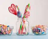 Dulces coloridos y piruletas en forma de corazón y espiral, perfectos para manualidades como regalar chuches.