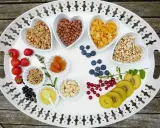 Bandeja con variedad de cereales, frutas y frutos secos, perfecta para una merienda cumpleaños infantil.