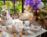 Mesa dulce para comunión con pastel, postres individuales, dulces y globos.