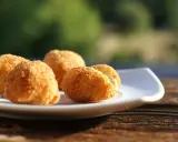 Croquetas caseras doradas y crujientes en un plato blanco, listas para disfrutar.