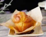 Un muffin dorado, recién horneado, envuelto en papel de horno. Perfecto para acompañar tu proceso de hacer masa madre.