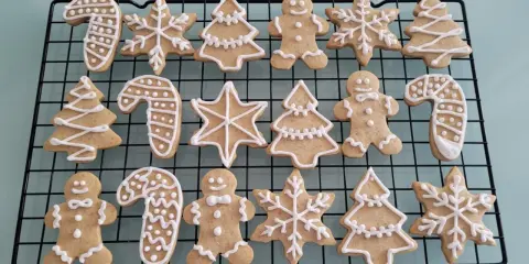 Galletas de jengibre navideñas con glaseado blanco: hombres de pan de jengibre, árboles, bastones de caramelo y copos de nieve.