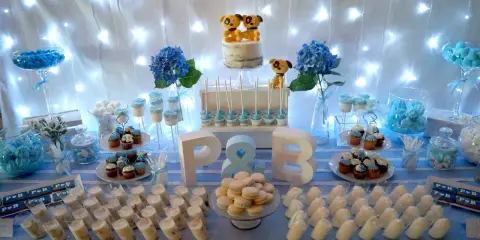 Mesa de dulces para una boda sencillo: pastel con perritos, cupcakes, macarons y postres individuales.
