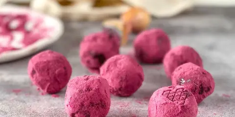 Deliciosas trufas de chocolate cubiertas de polvo rosa vibrante. Un bocado dulce y tentador.