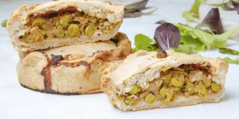 Empanadas mallorquinas rellenas de guisantes y carne, con una masa dorada y crujiente.