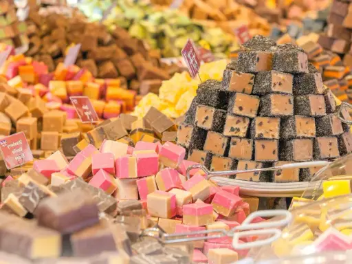 Montón de caramelos de antes, de diferentes sabores y colores, apilados en un puesto.